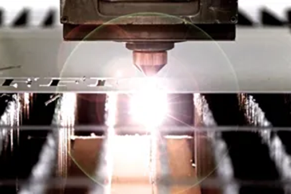 hands holding a piece of metal and machine drilling a hole in it